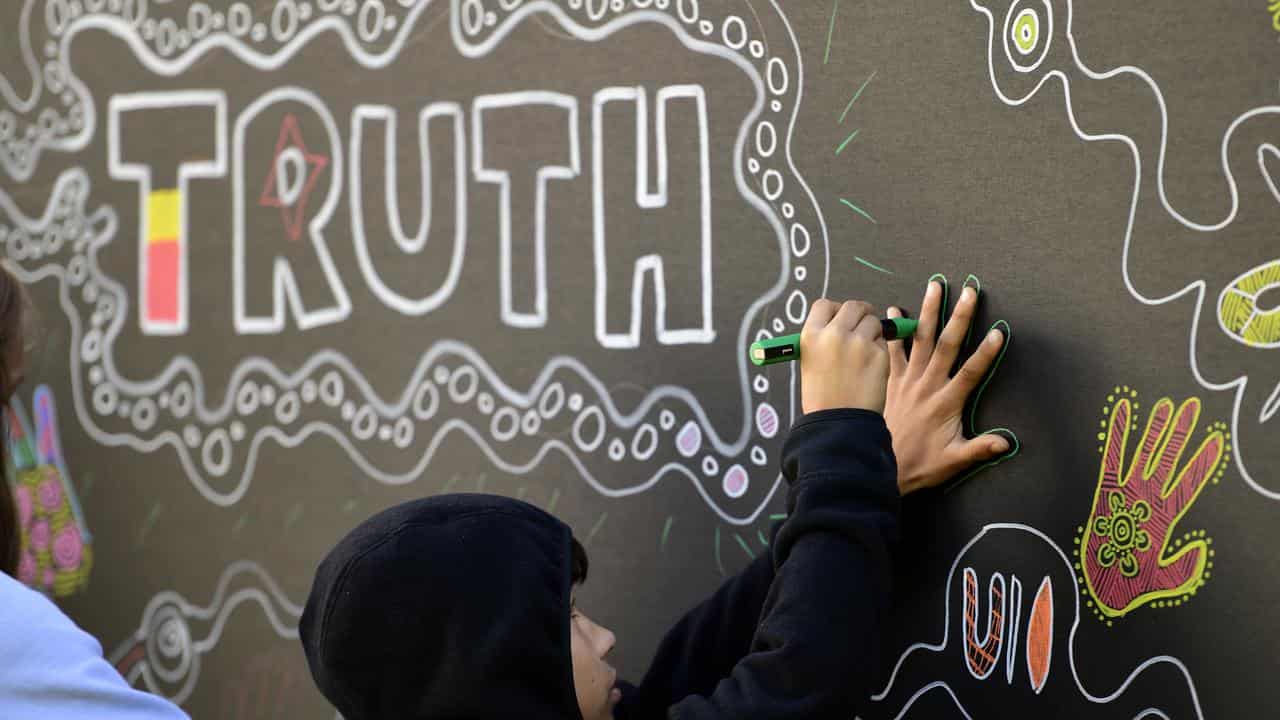 A boy traces his hand on a sign (file image)