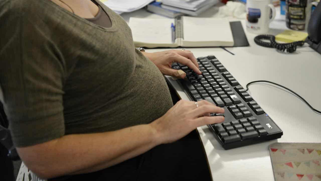 A pregnant woman working at a computer (file image)