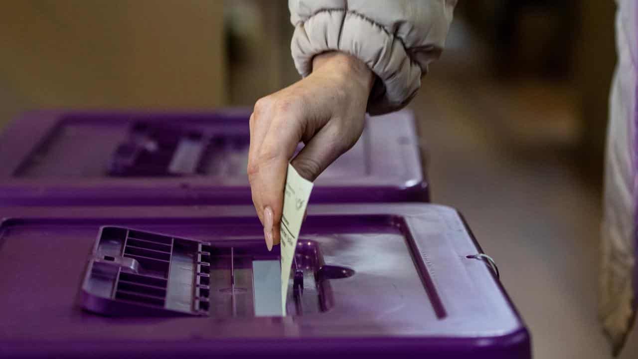 A person places a vote in a ballot box (file image)