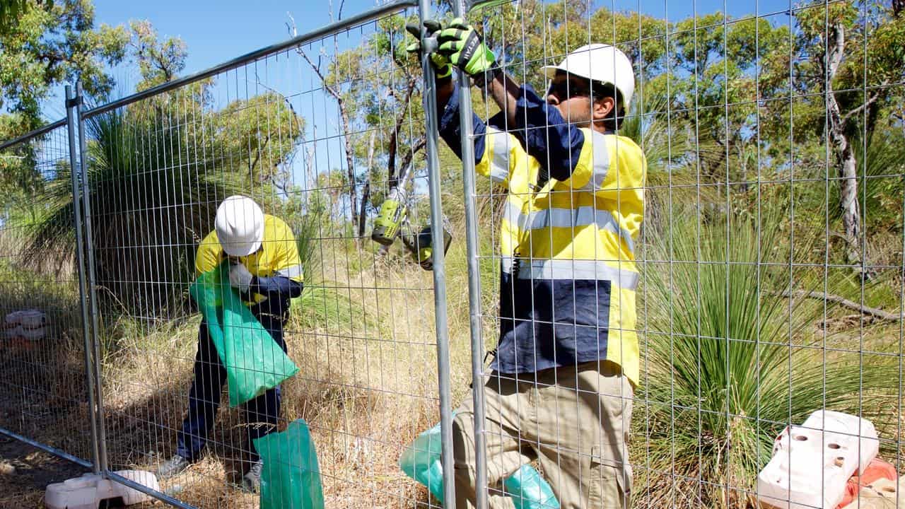 Men constructing a fence.