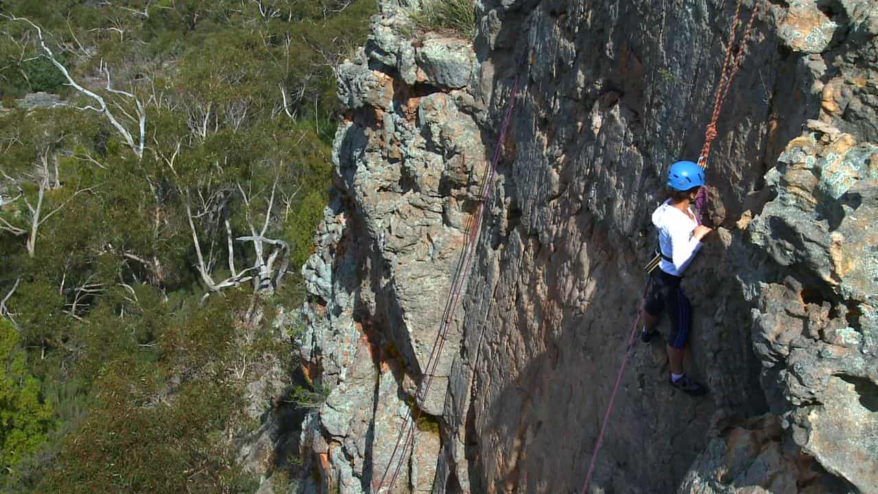 A climber scales a rock in Victoria's Grampians region