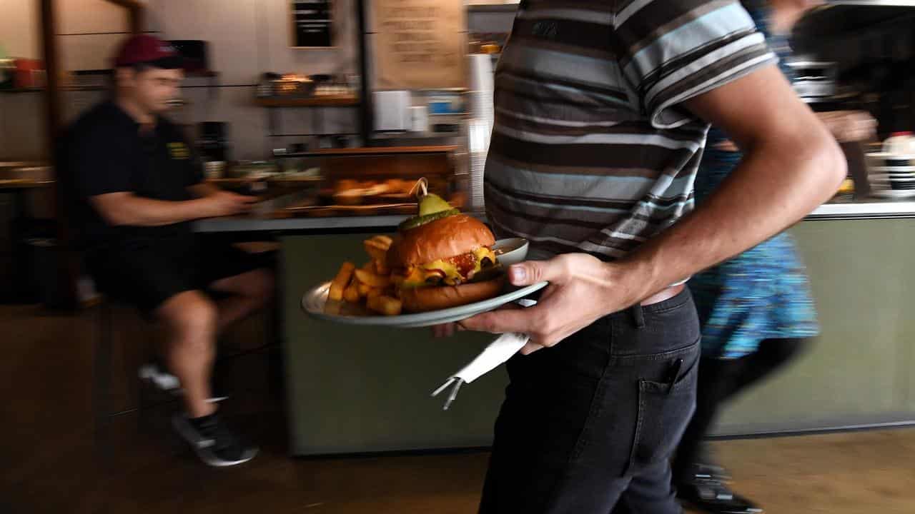 An employee serving a plate of food at a cafe (file image)