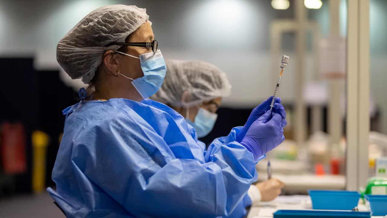 A health care worker fills a syringe (file image)