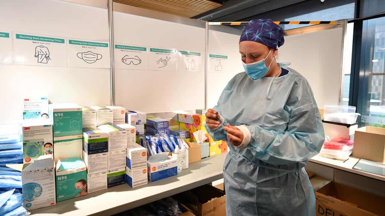 A healthcare worker preparies to administer a COVID-19  test.