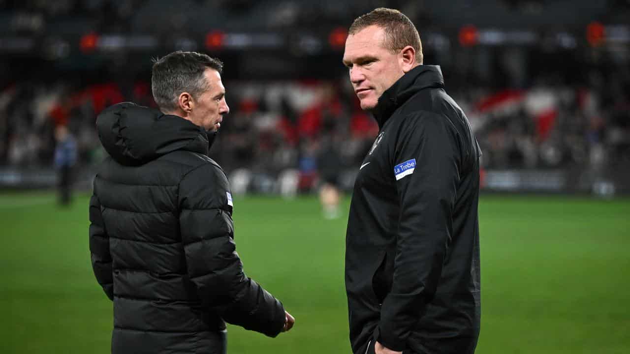 Collingwood coach Craig McRae (left) chats with Justin Leppitsch.