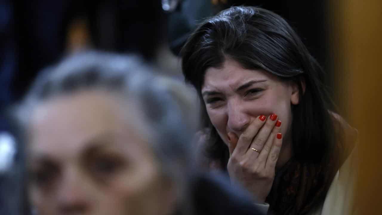 A woman weeps at a memorial for victims.