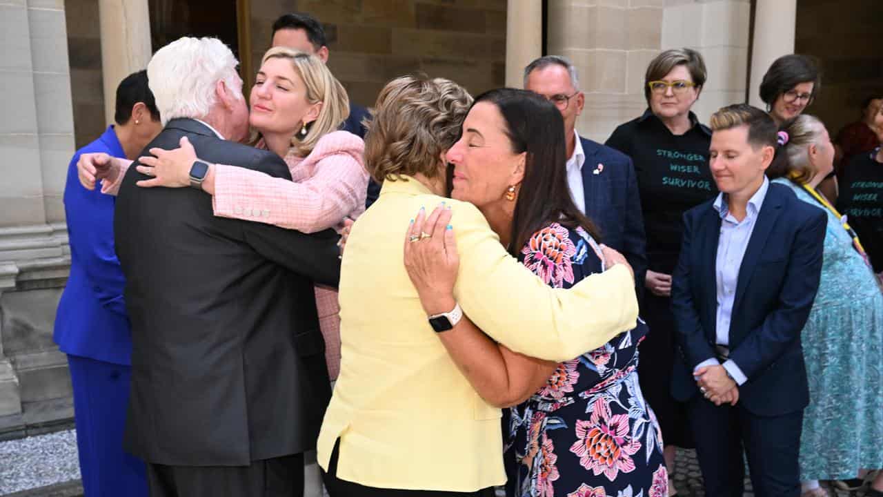 Priscilla Dickie hugs Sue Clark outside Queensland parliament