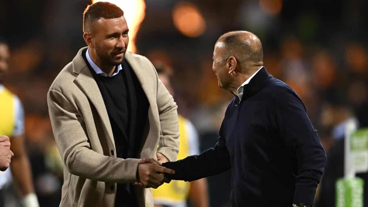 Quade Cooper (left) shakes hands with Eddie Jones