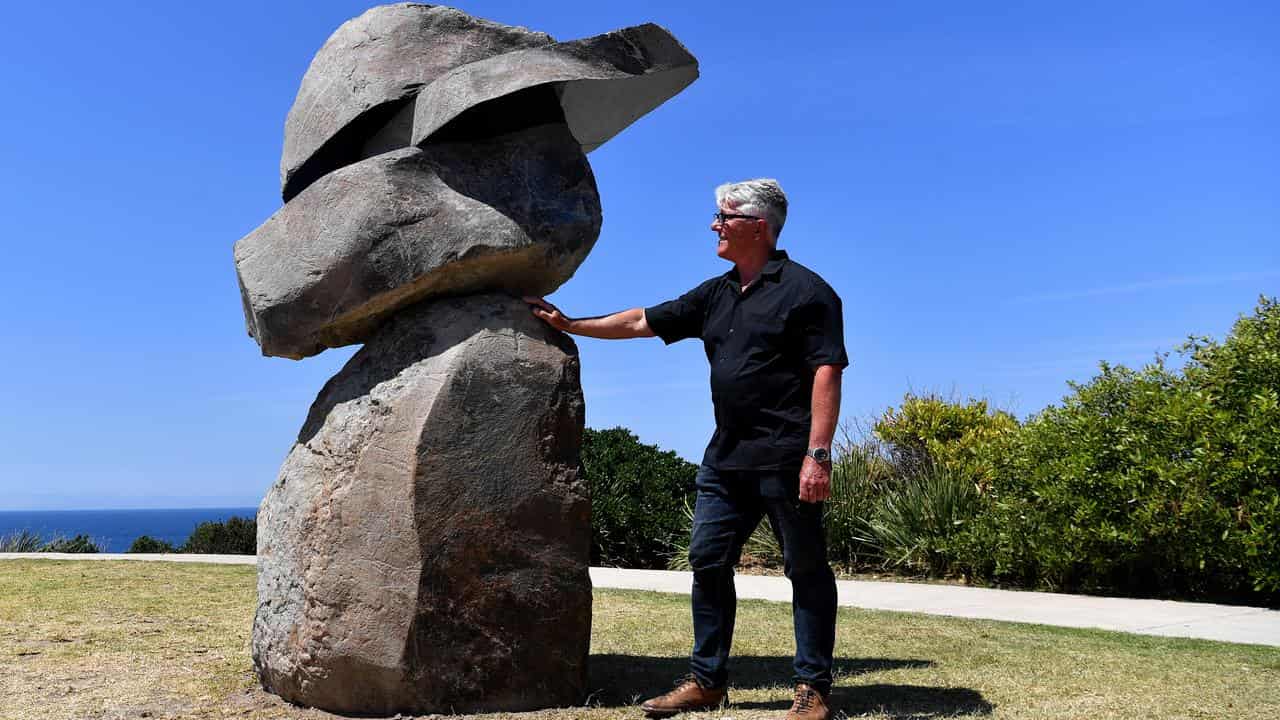 Artist with rock scuplture