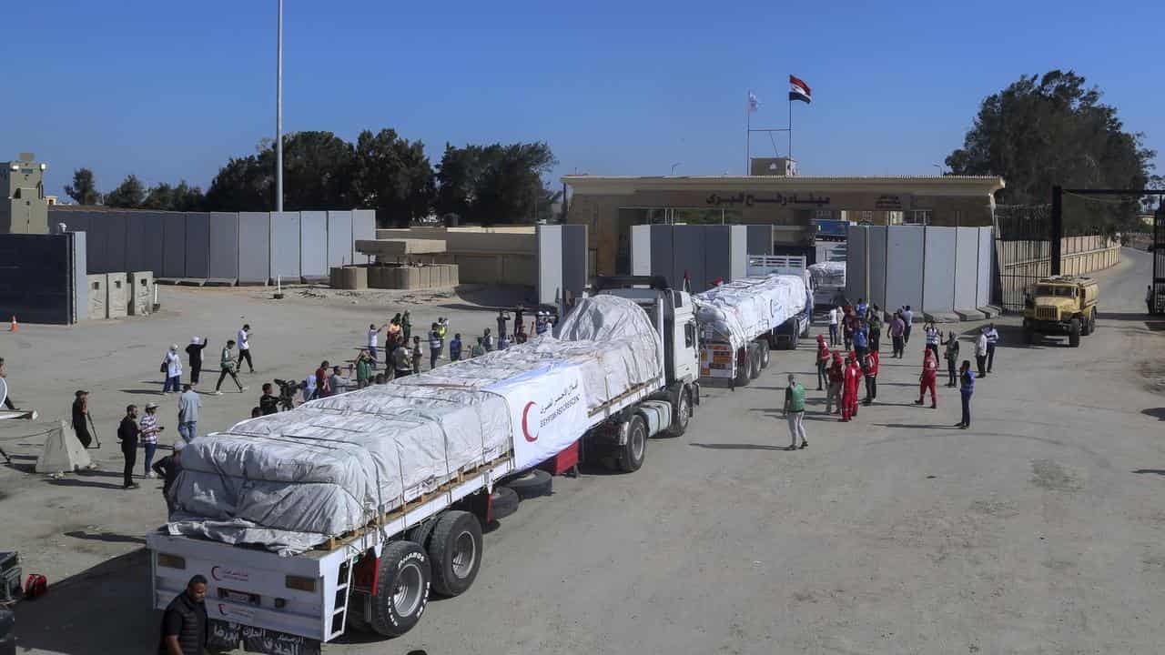 Trucks carrying humanitarian aid pass the Rafah border gate into Gaza.