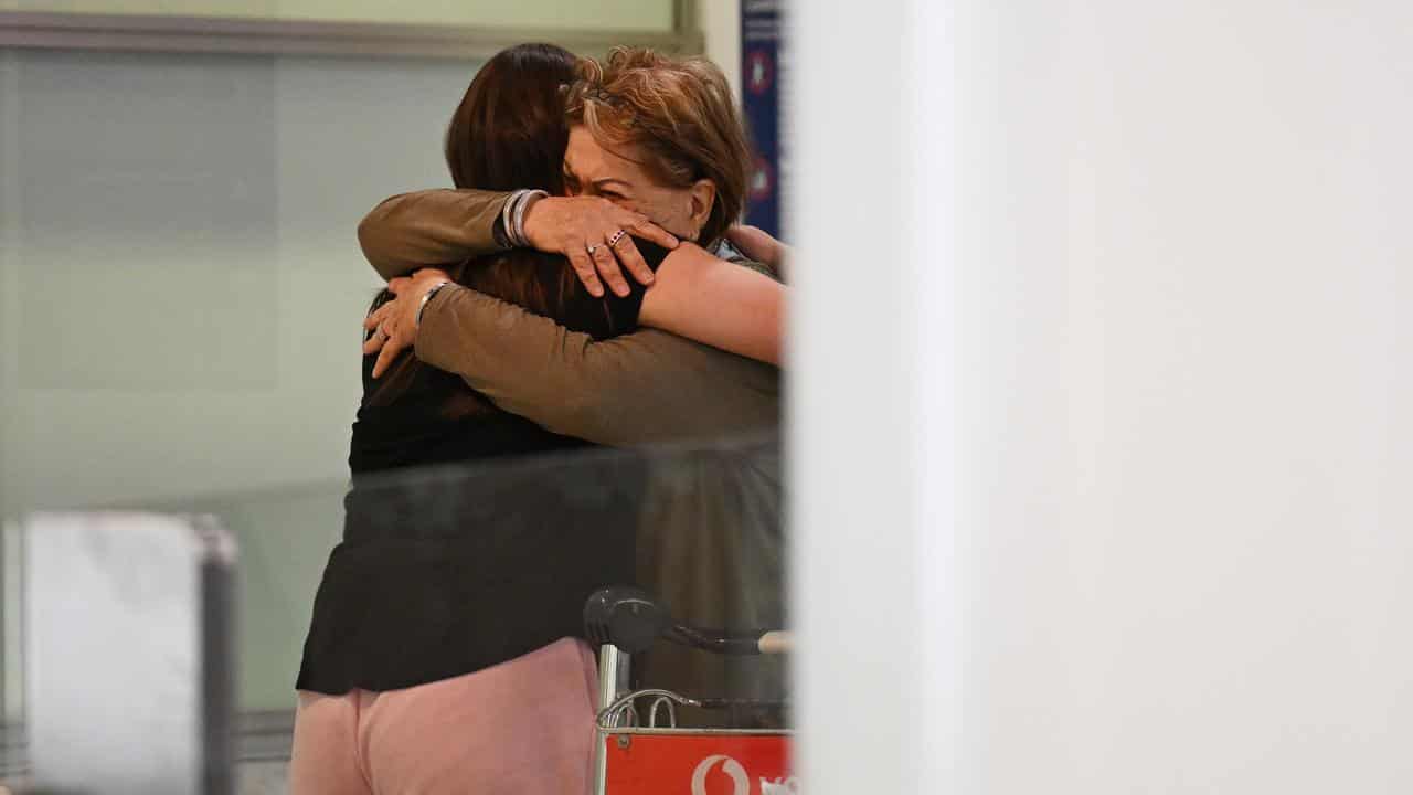 Two passengers embrace at airport