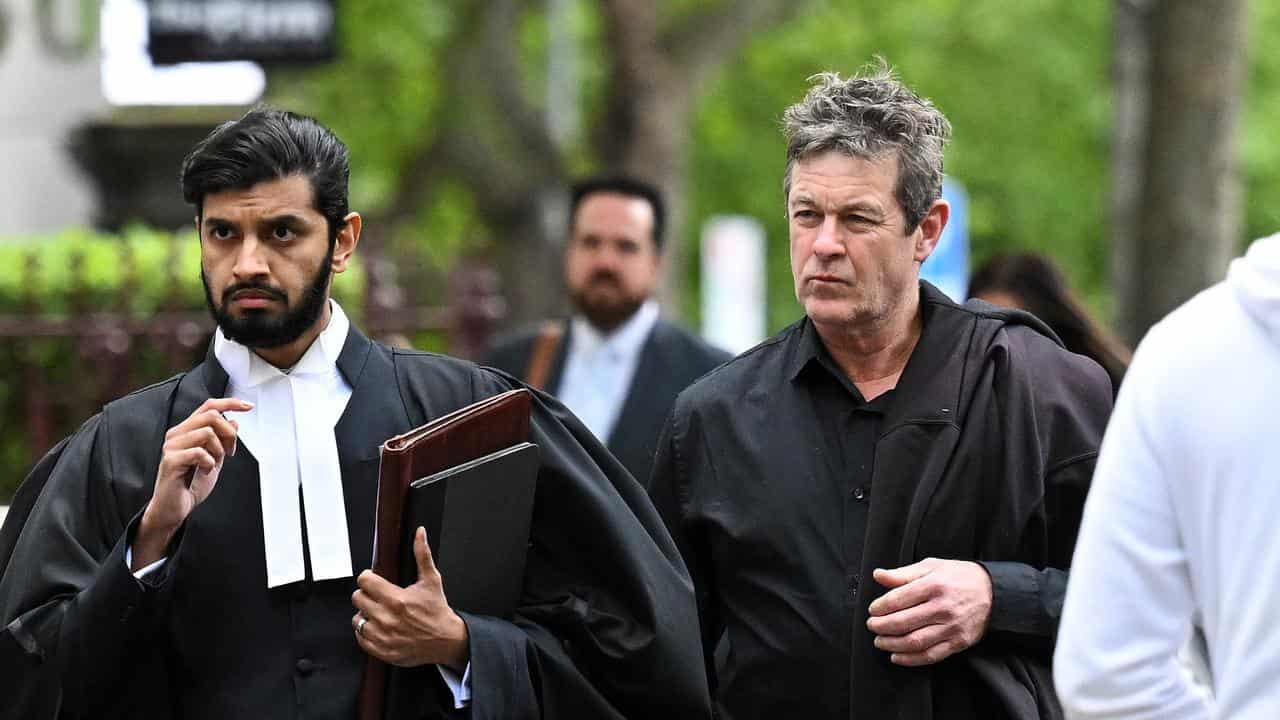 Russell Northe (centre) arrives to the County Court of Victoria