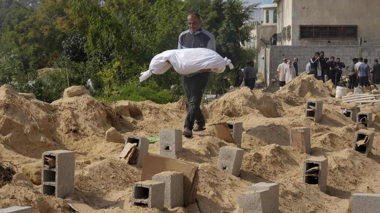 Palestinians bury the bodies of their relatives