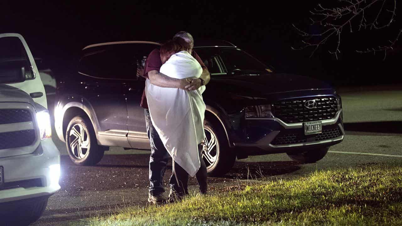 A woman is hugged by a man