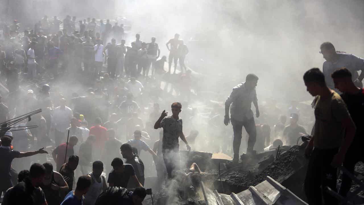 Palestinians inspect the rubble of destroyed buildings