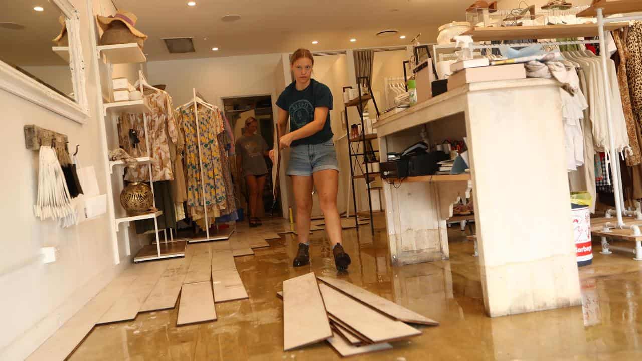 Staff clean up after flood damage at a Byron Bay boutique