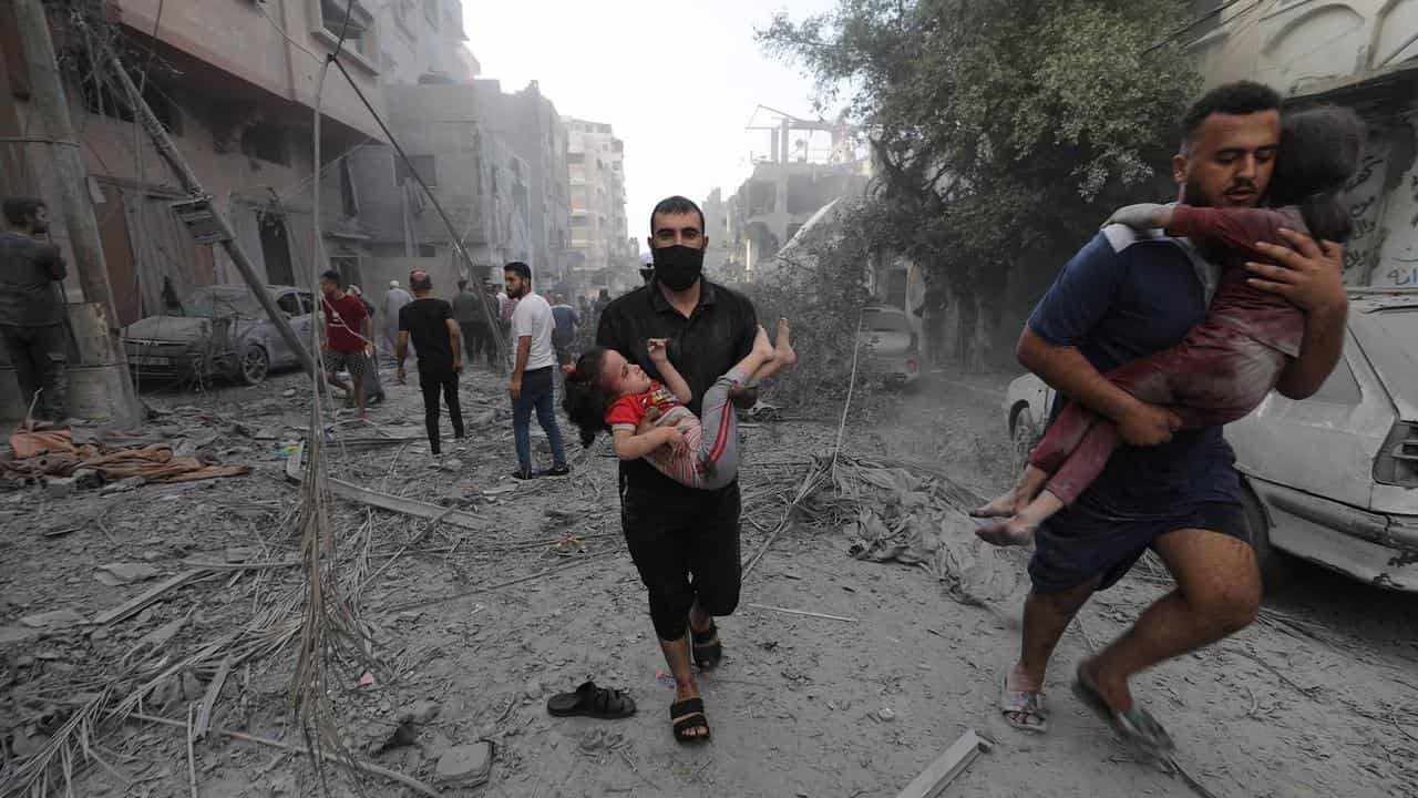 Palestinians carry wounded children following Israeli airstrikes