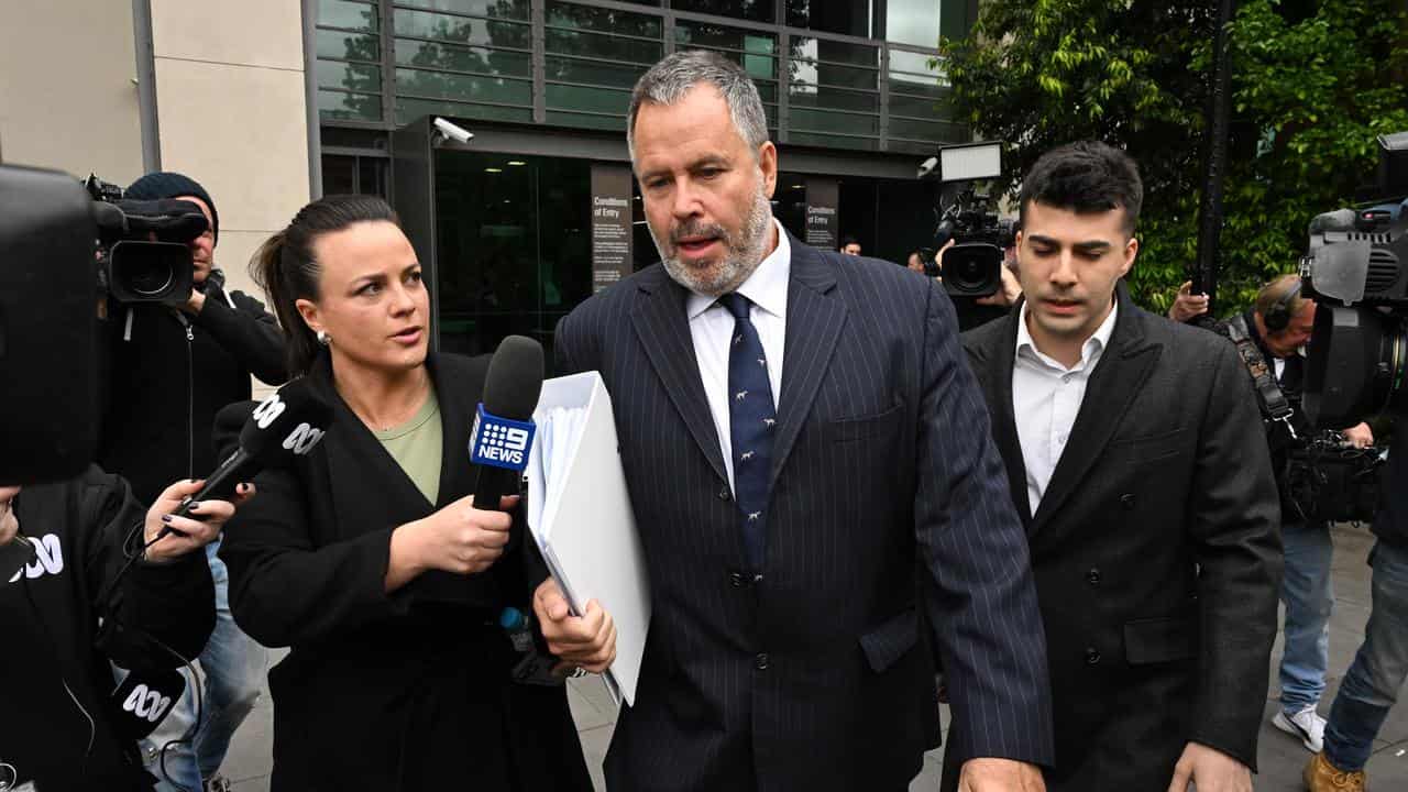 Lawyer Bill Doogue (centre) departs the Latrobe Valley Law Courts