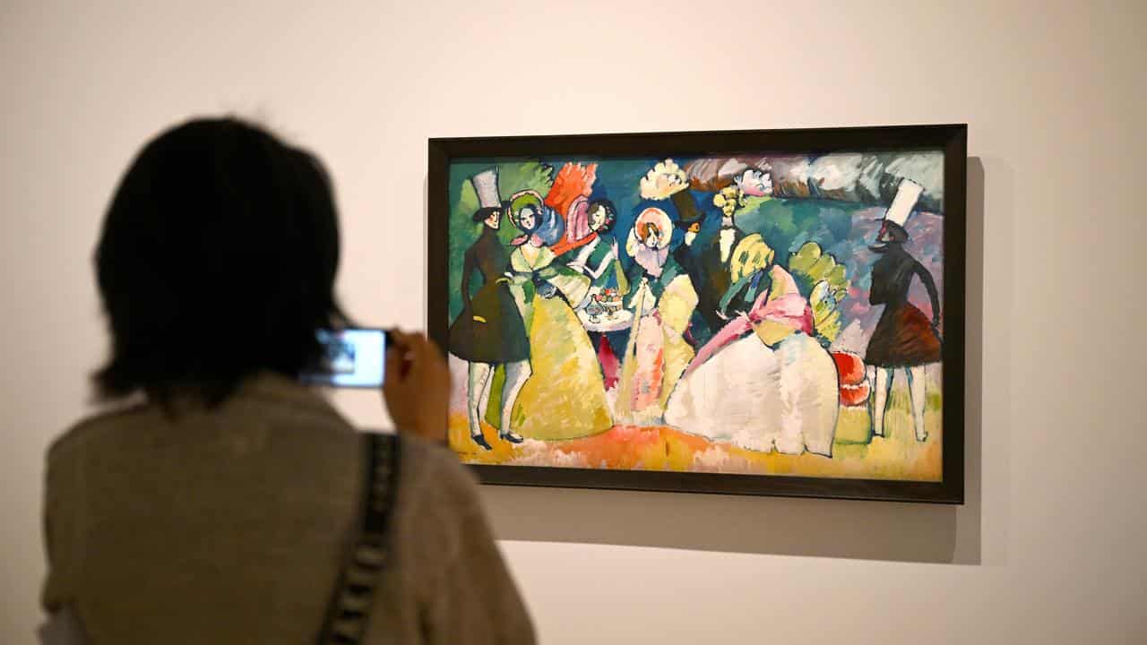 Person photographs an artwork by Vasily Kandinsky.