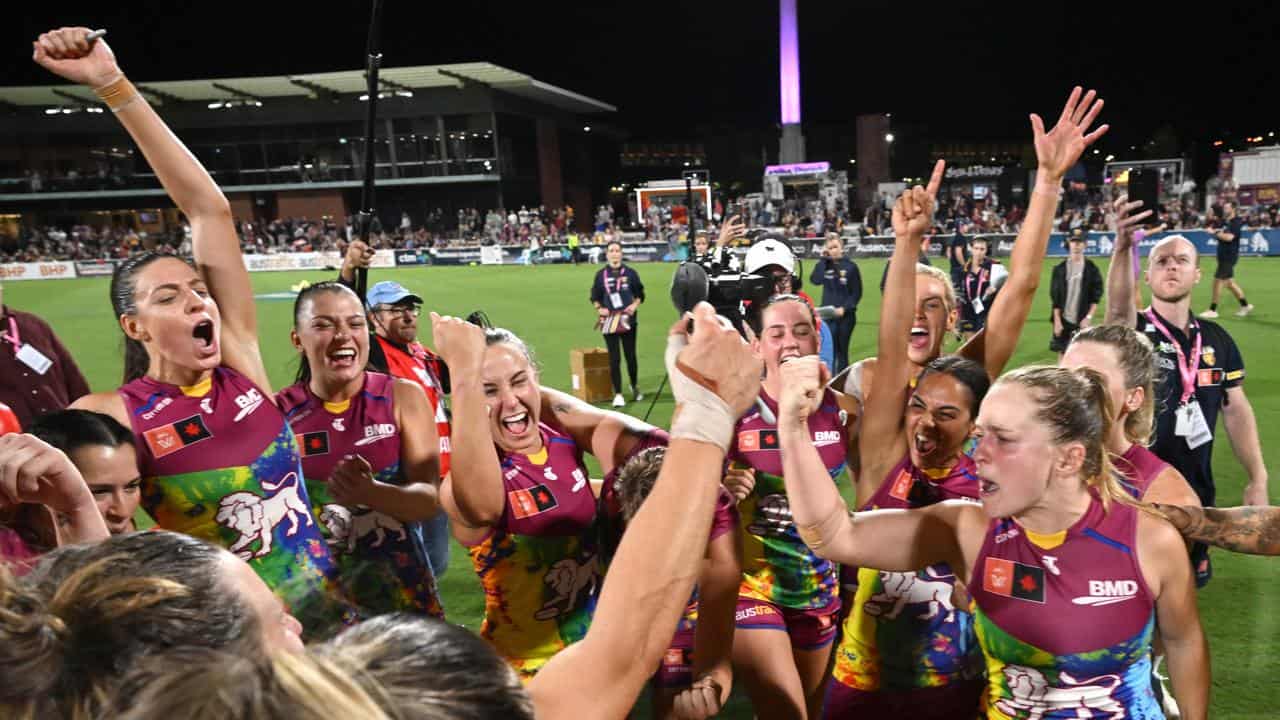 Lions players celebrate beating Melbourne.