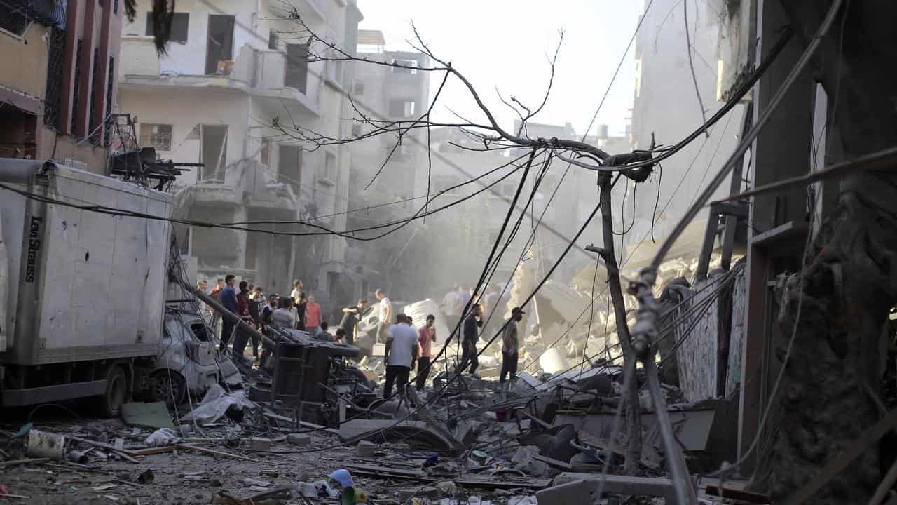 Palestinians inspect the damage following an Israeli airstrike