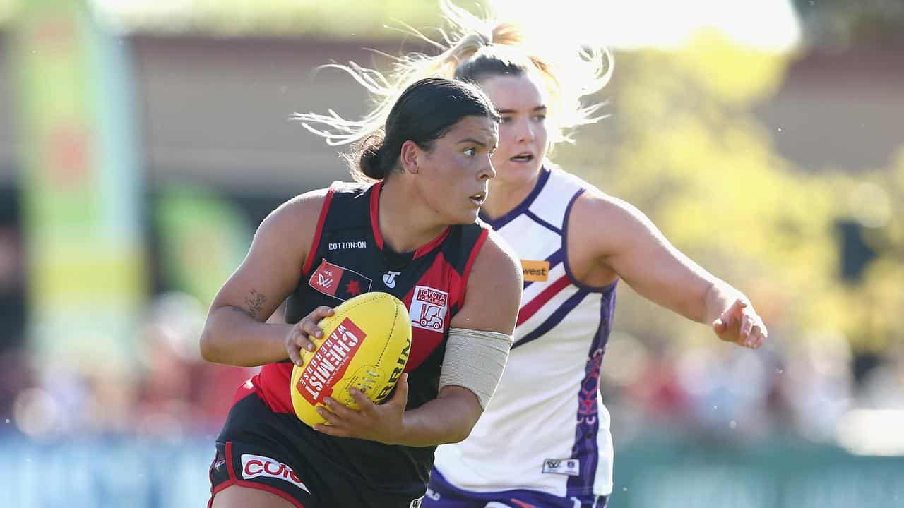 Madison Prespakis (left) gets on the ball for Essendon in the AFLW.