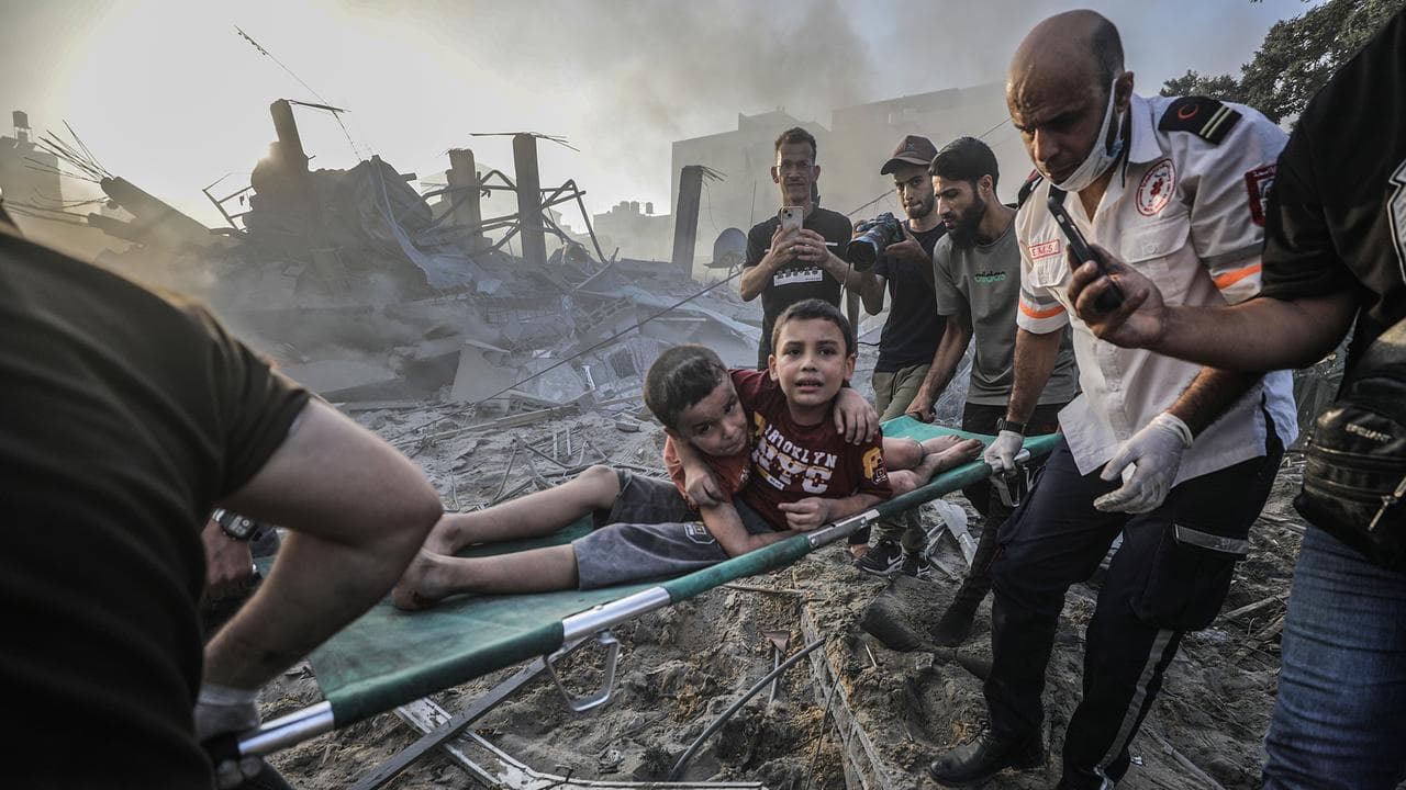 Palestinians carry wounded brothers following air strikes in Gaza City