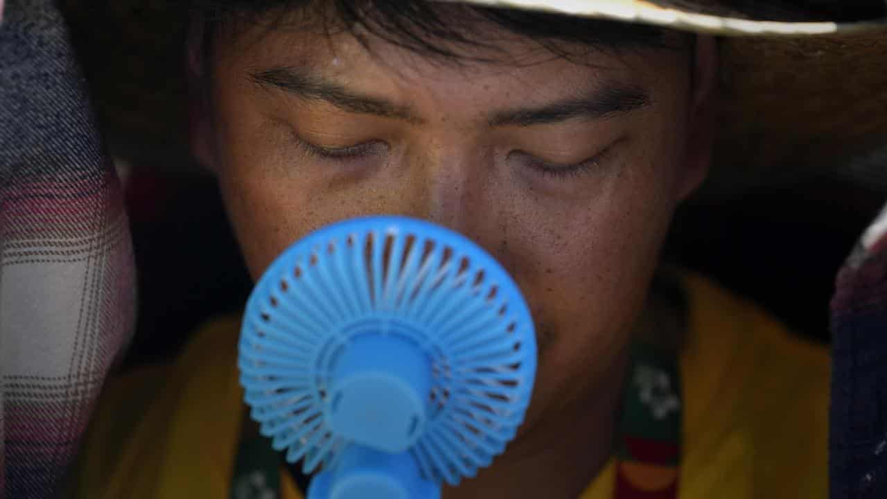 A World Youth Day volunteer tries to cool down near Lisbon, Portugal