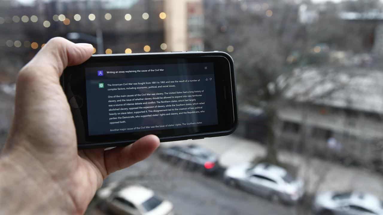 A ChatGPT prompt is shown on a device near a public school