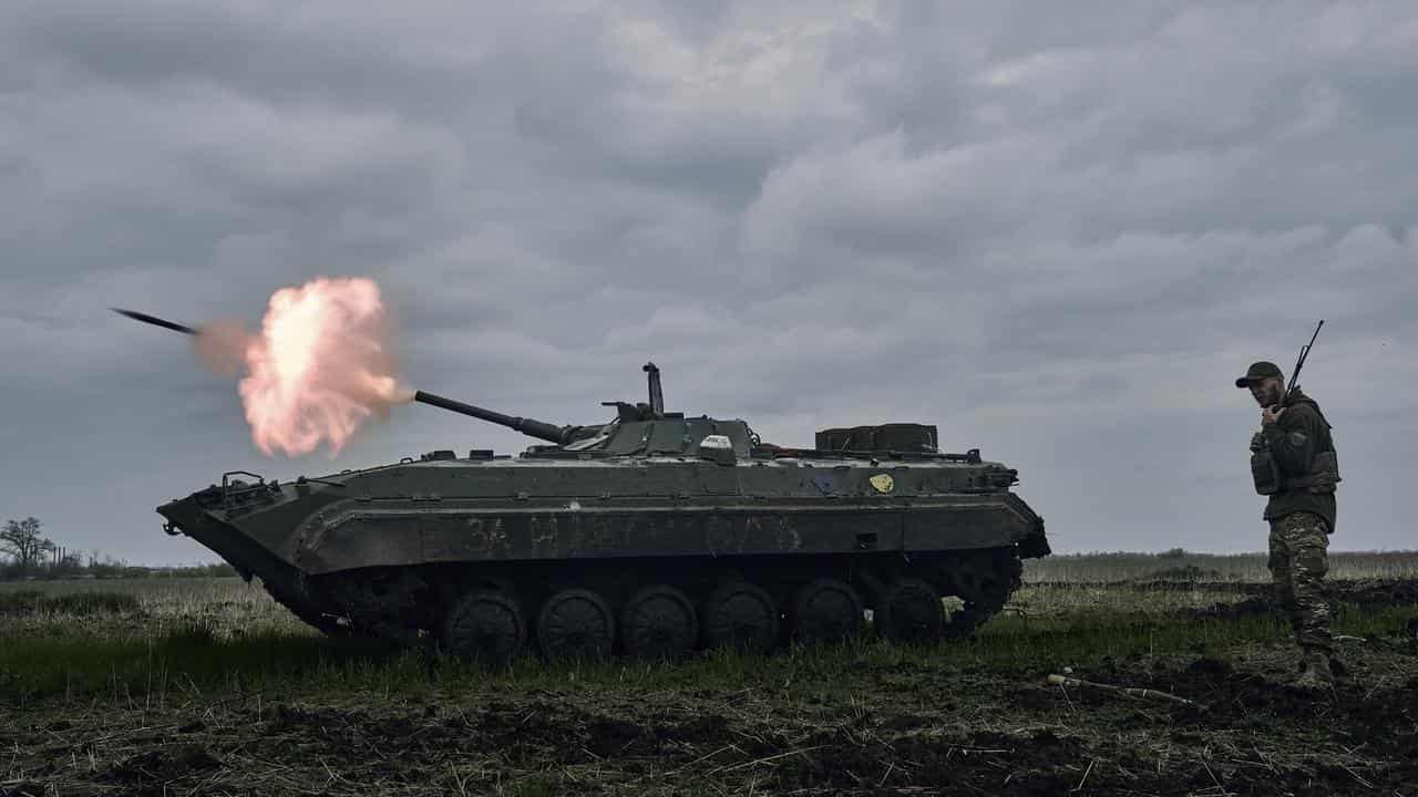 A Ukrainian APC fires towards Russian positions near Avdiivka