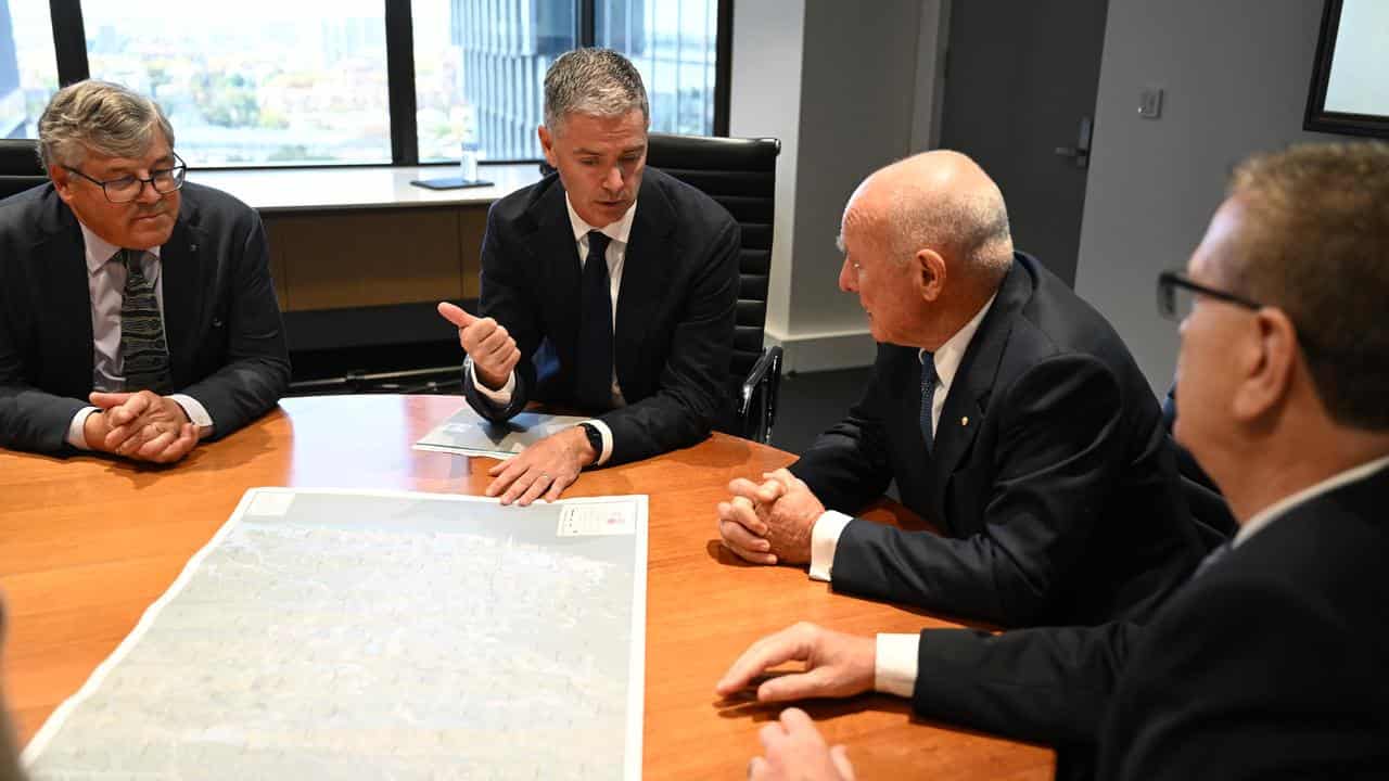 John Graham (2nd left)  briefs Allan Fels (2nd from right) in April.