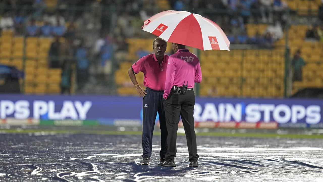 Umpires standing in the rain.