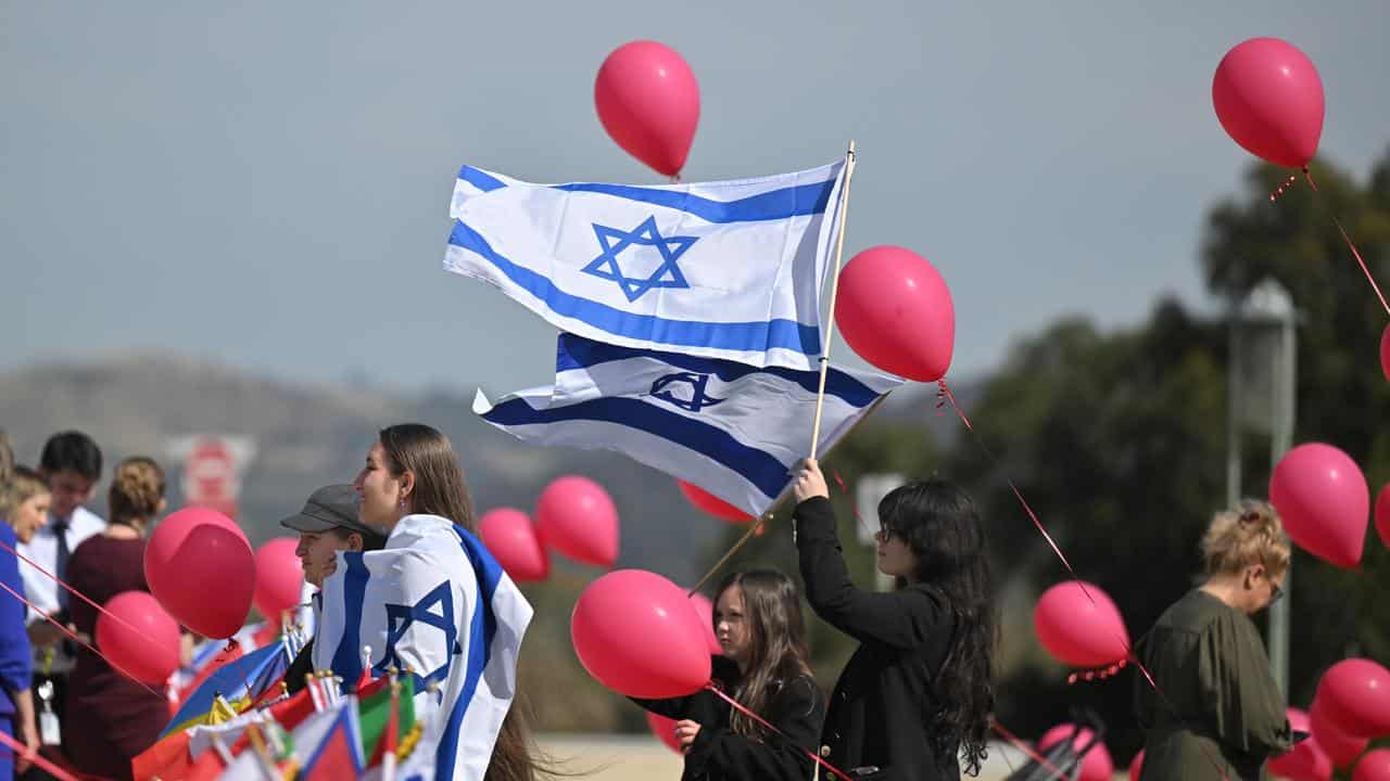 Flags and balloons representing kidnapped Israelis in Gaza at a rally