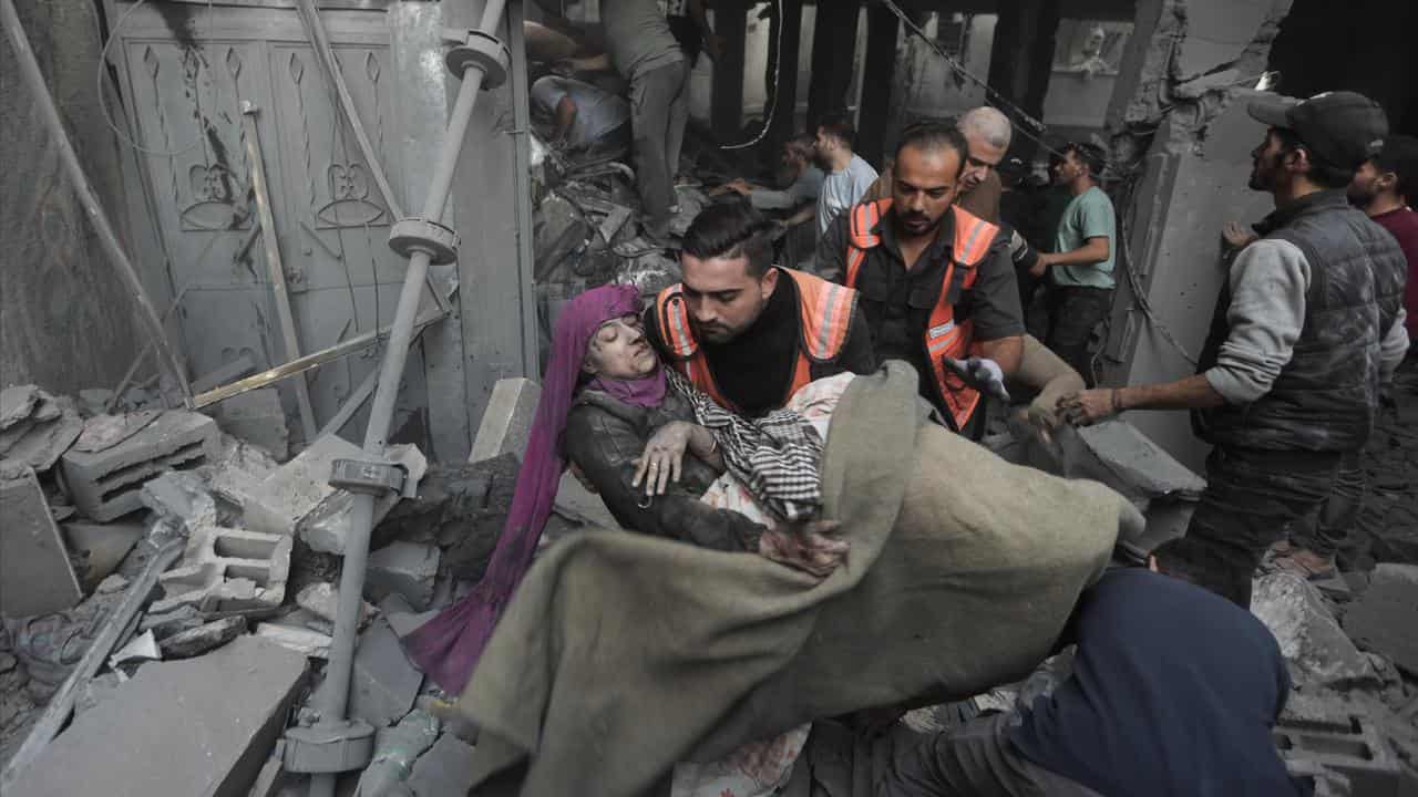 Palestinian rescuers evacuate an injured woman