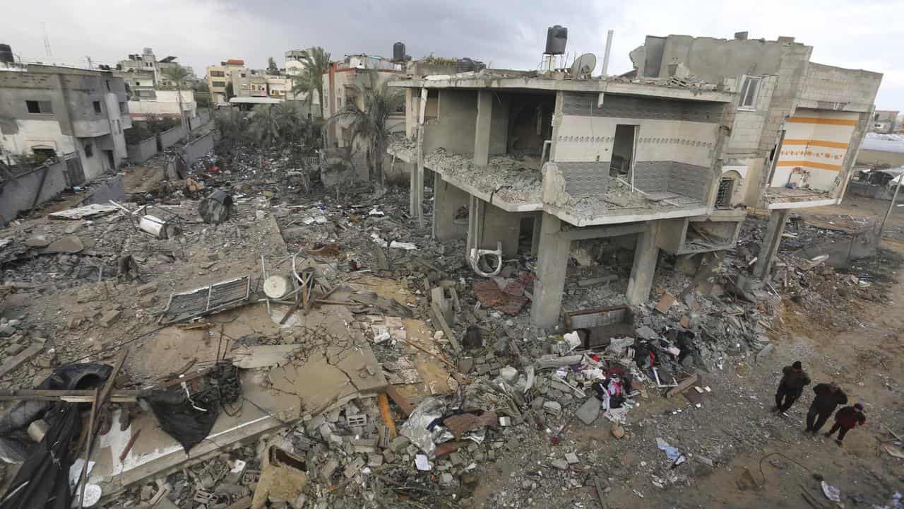 Palestinians look at desctruction from the Israeli bombardment of Gaza