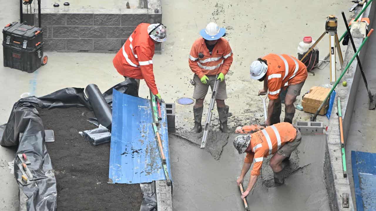 A construction worker uses a concrete float