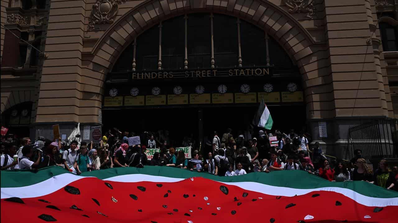 Pro-Palestine students hold a large cloth watermelon.