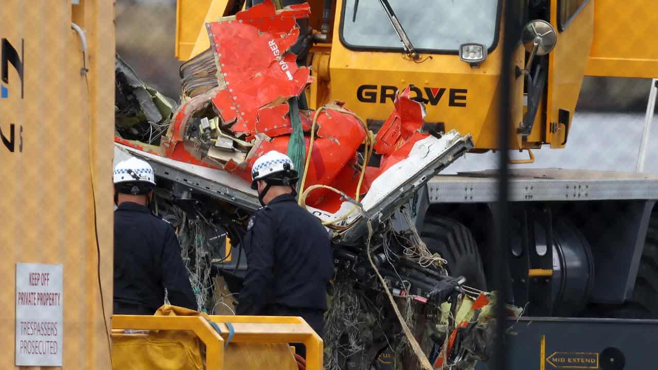 olice and salvage crew with plane wreckage