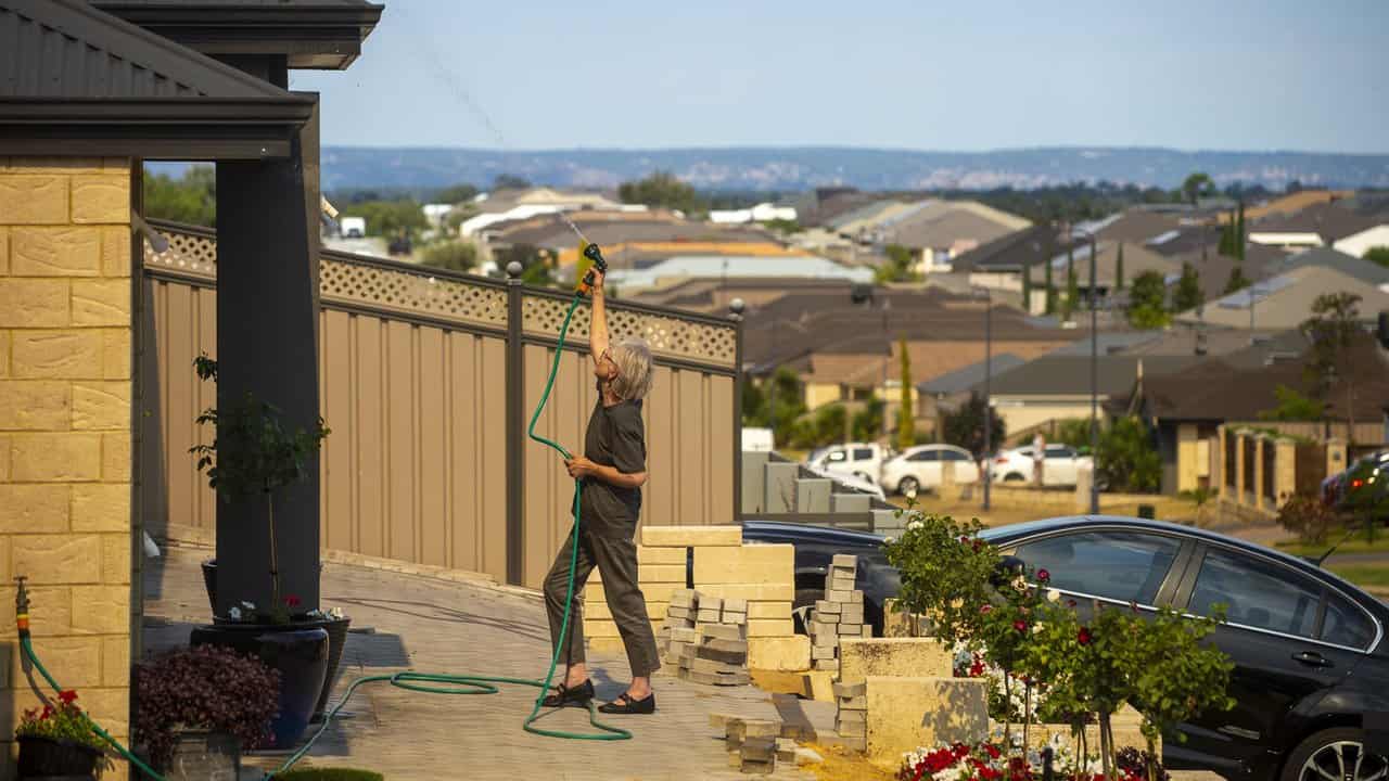 A woman hosing her gutters