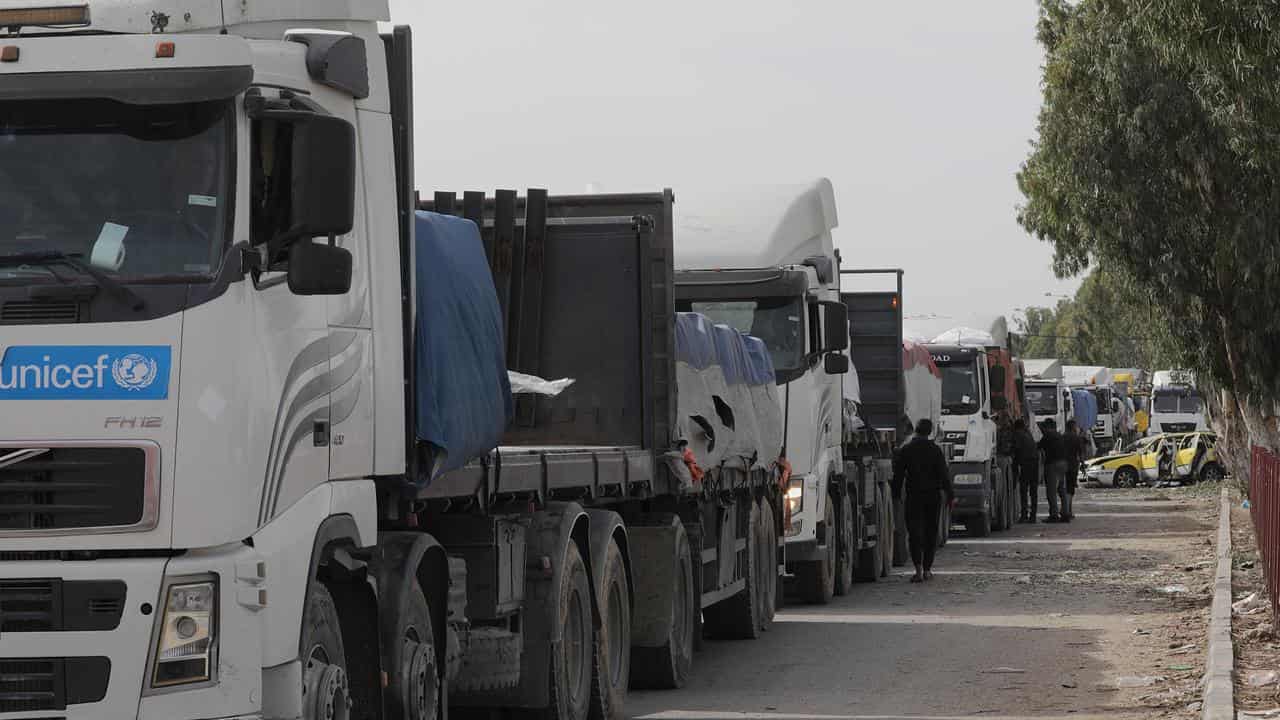 Trucks carrying humanitarian aid wait to cross into northern Gaza