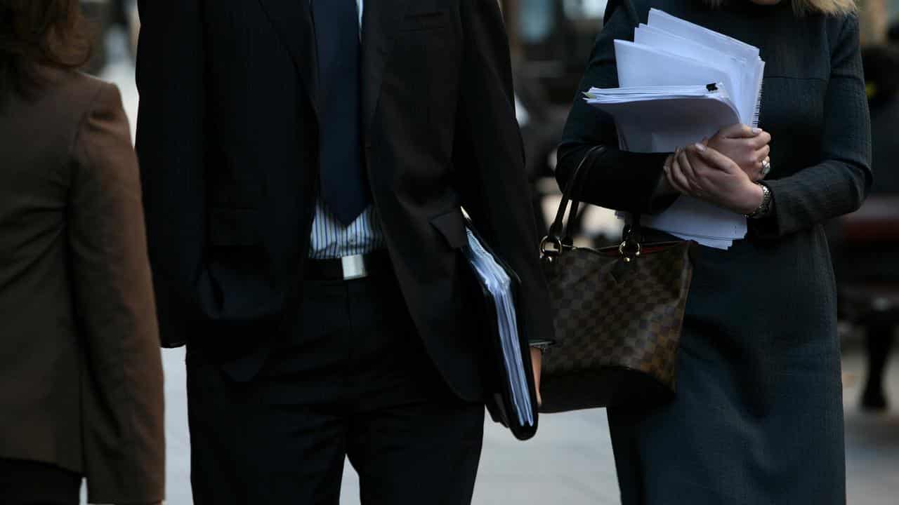 Workers carrying documents walk down Martin Place, Sydney,