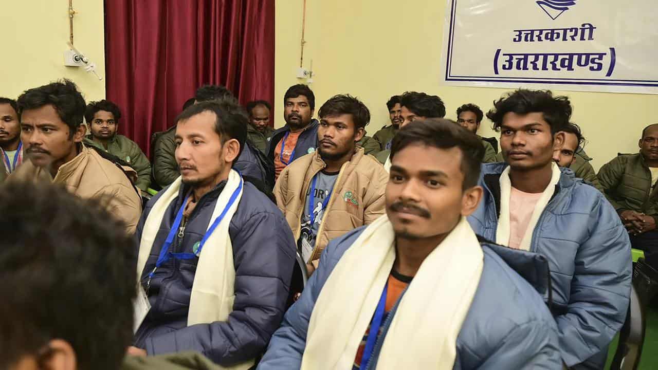 Rescued workers listen to a phone call from Indian PM Narendra Modi