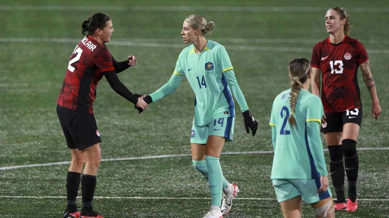 Christine Sinclair shakes hands with Alanna Kennedy.