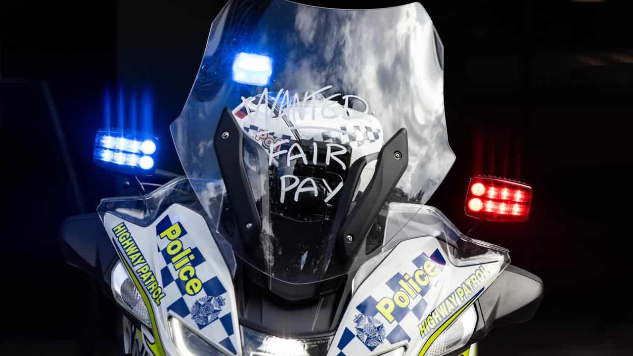 A sign of protest is seen on a police motorbike.