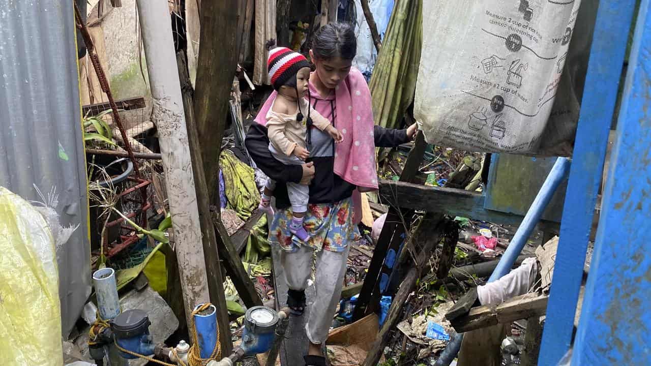 Residents walk past damages caused by an earthquake