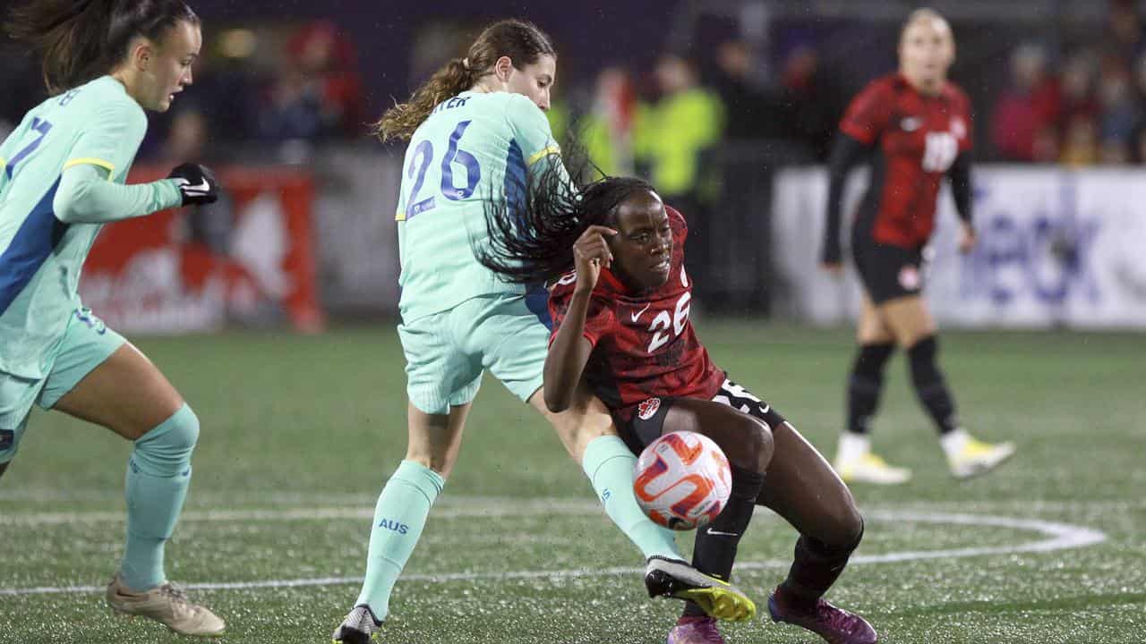 Sarah Hunter (26) makes a tackle for Australia against Canada.