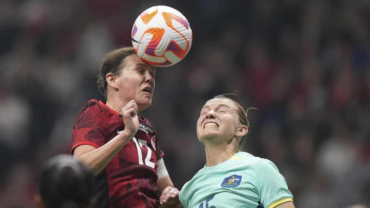 Christine Sinclair beats Clare Hunt to a header.