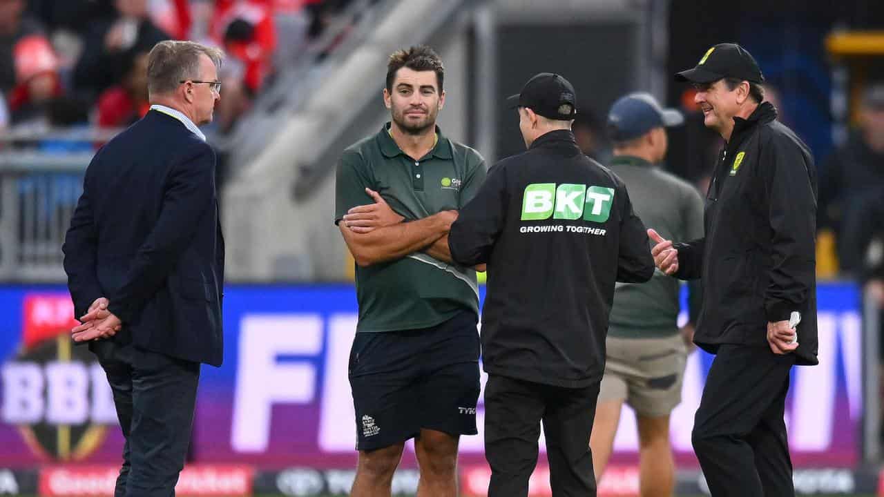 Match officials and ground staff confer.