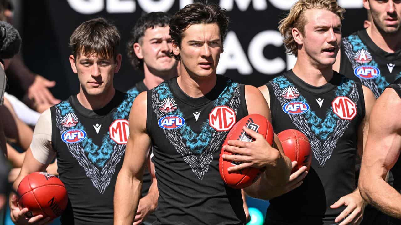 Port Adelaide's Zak butters (left) and Connor Rozee (centre).