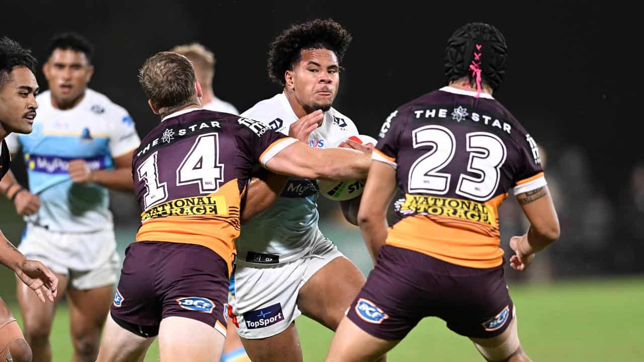 Josiah Pahulu is tackled by Brisbane Broncos players. 